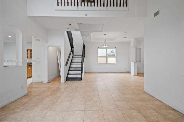 interior space with light tile patterned flooring and a raised ceiling