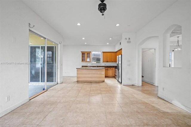 kitchen with light tile patterned floors, stainless steel fridge, and sink