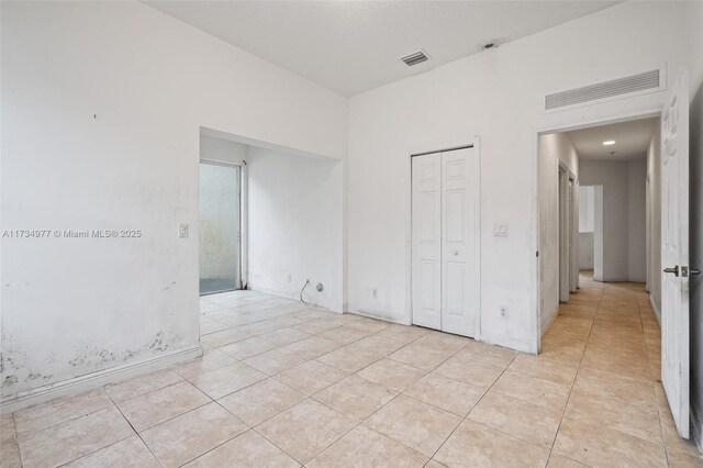 unfurnished bedroom featuring light tile patterned floors and a closet