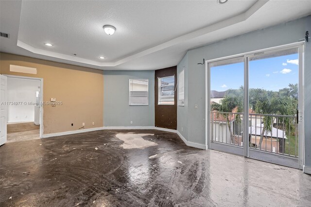 empty room with a raised ceiling and a textured ceiling