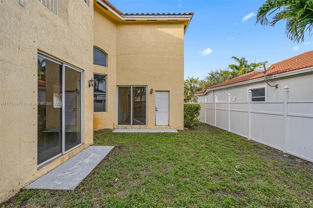 back of property with a balcony, a yard, and a patio area