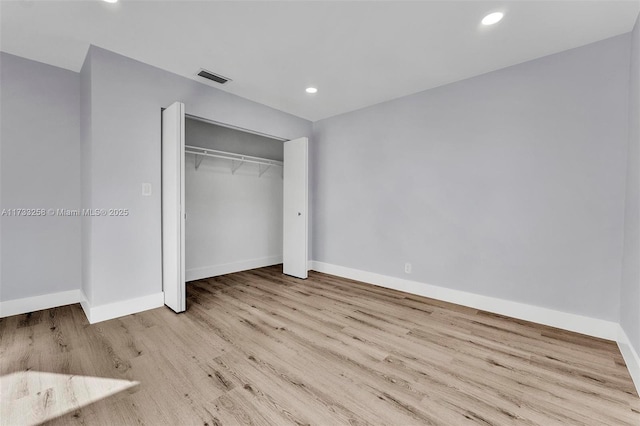 unfurnished bedroom with a closet and light wood-type flooring