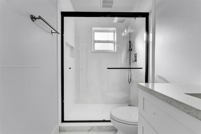 bathroom featuring vanity, toilet, and a shower with shower door