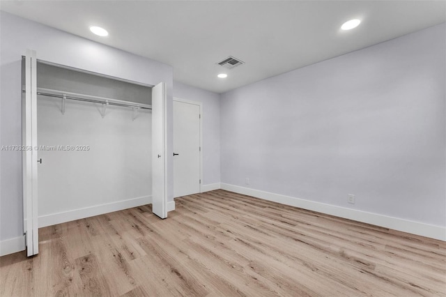 unfurnished bedroom with a closet and light hardwood / wood-style flooring