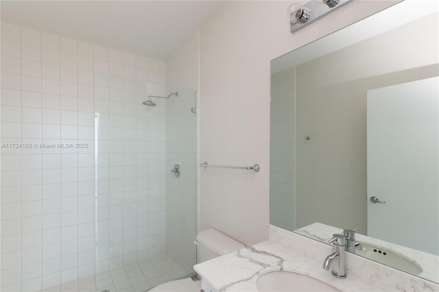 bathroom featuring tiled shower, vanity, and toilet