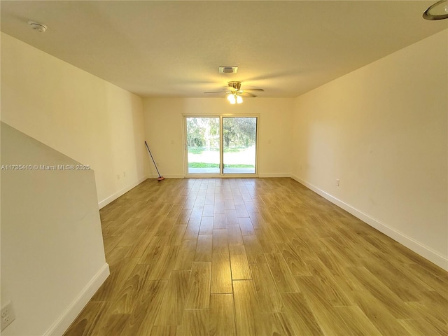 unfurnished room with ceiling fan, light wood-style flooring, visible vents, and baseboards