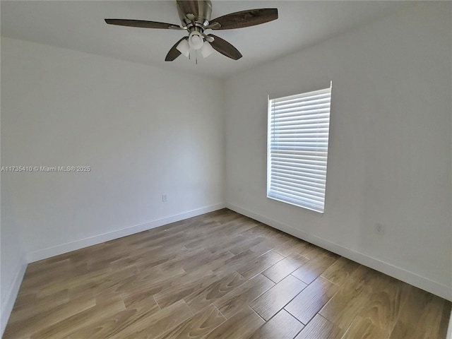 spare room with light wood-style floors, ceiling fan, and baseboards