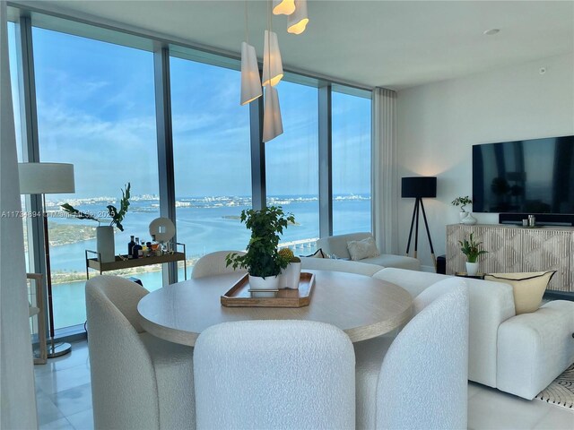 dining space featuring a water view and expansive windows