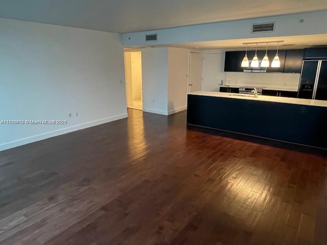 kitchen featuring hanging light fixtures, dark hardwood / wood-style floors, sink, and black built in fridge