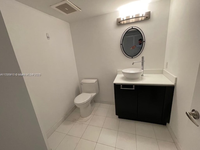 bathroom with vanity, toilet, and tile patterned flooring