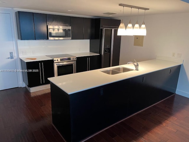 kitchen featuring hanging light fixtures, appliances with stainless steel finishes, sink, and kitchen peninsula