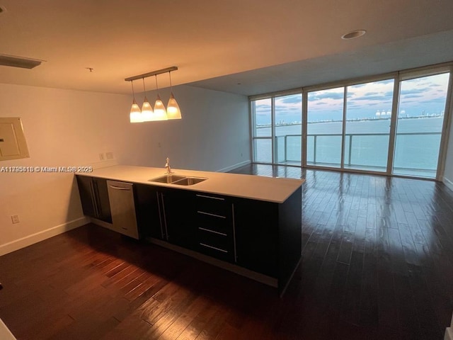 kitchen with pendant lighting, dishwasher, sink, dark hardwood / wood-style flooring, and kitchen peninsula