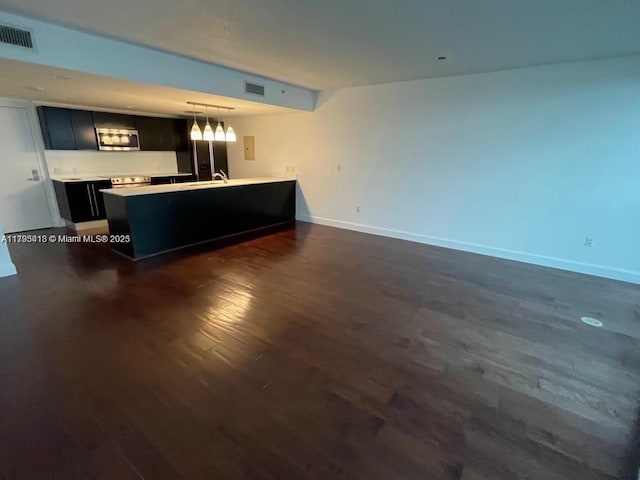 unfurnished living room with dark wood-type flooring and sink