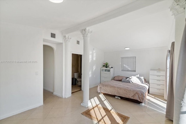 tiled bedroom featuring vaulted ceiling with beams and decorative columns