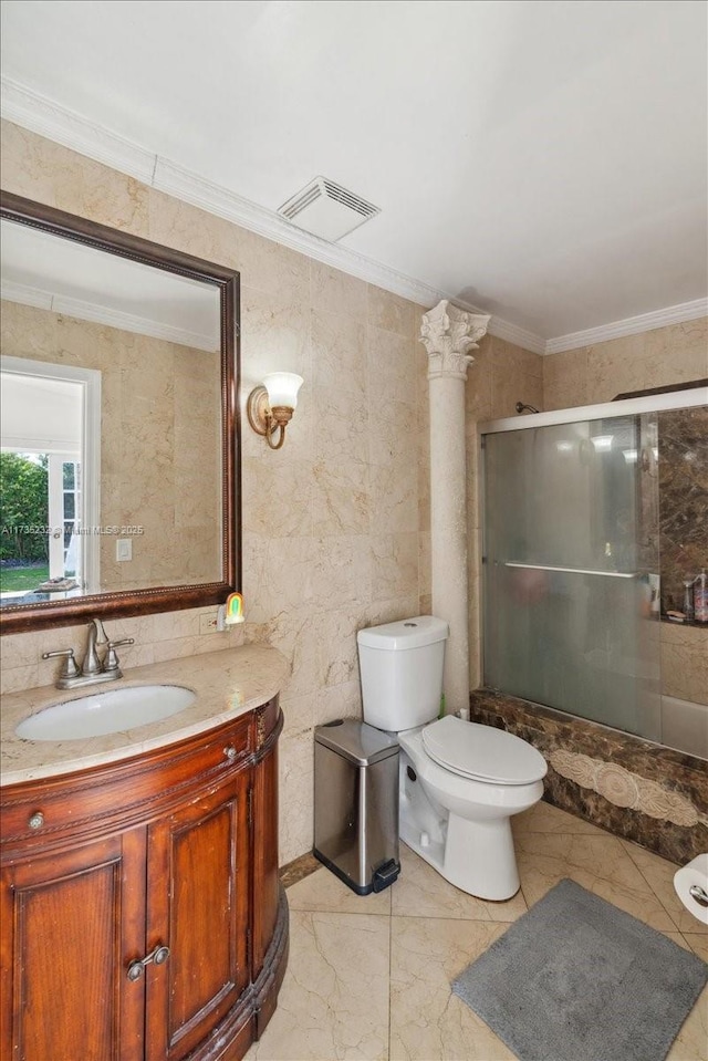 bathroom with a shower with door, ornamental molding, vanity, and ornate columns