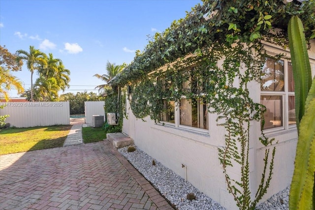 view of side of property with central AC and a patio area