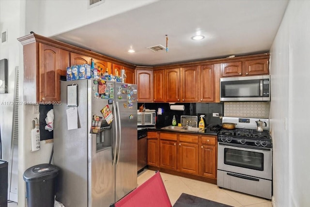 kitchen featuring stainless steel appliances, light tile patterned flooring, sink, and backsplash