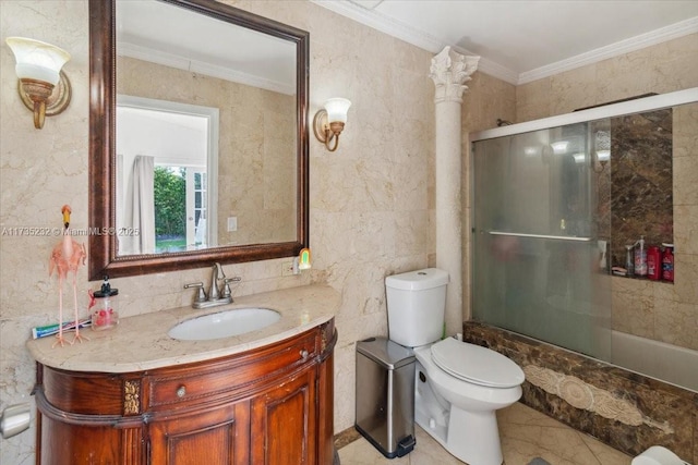 full bathroom featuring toilet, combined bath / shower with glass door, crown molding, tile walls, and vanity