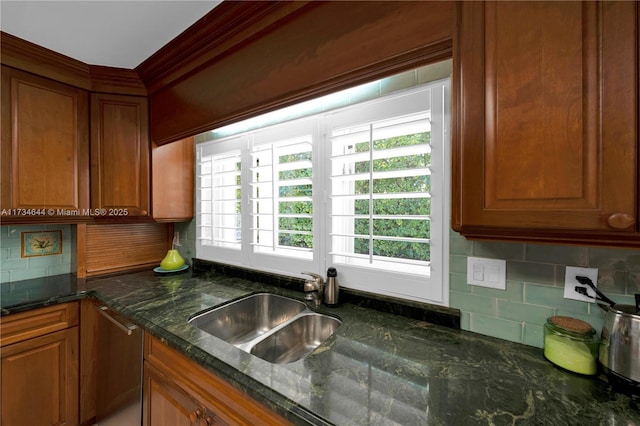 kitchen with backsplash, sink, and dark stone countertops