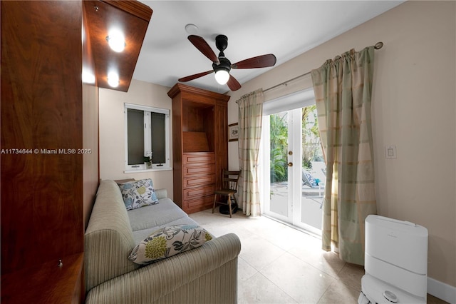 living area featuring ceiling fan and light tile patterned flooring