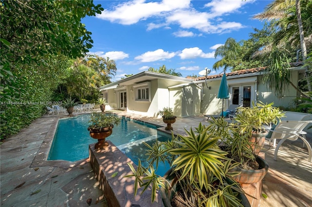 view of swimming pool with french doors and a patio area