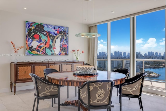 dining room featuring a water view, expansive windows, and light tile patterned floors