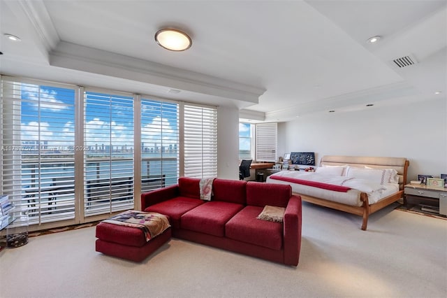 bedroom featuring a tray ceiling, carpet floors, and ornamental molding