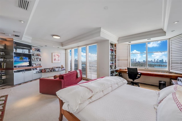 carpeted bedroom with crown molding, a raised ceiling, and built in desk