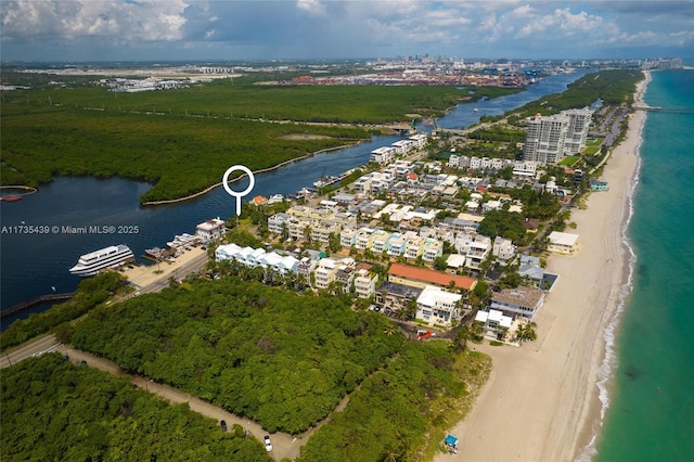 drone / aerial view featuring a water view and a beach view