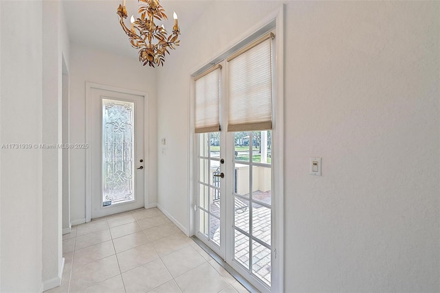 doorway featuring an inviting chandelier and light tile patterned flooring