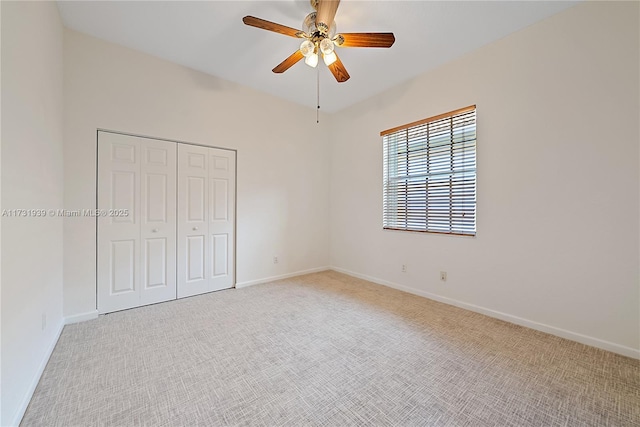 unfurnished bedroom featuring ceiling fan, a closet, and light carpet