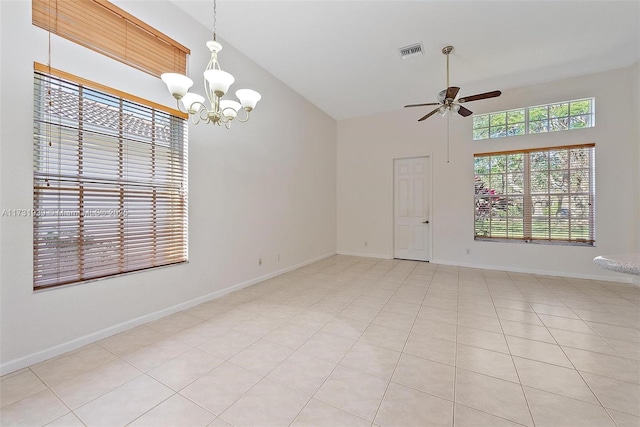 tiled spare room with ceiling fan with notable chandelier and high vaulted ceiling