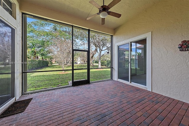 unfurnished sunroom with ceiling fan