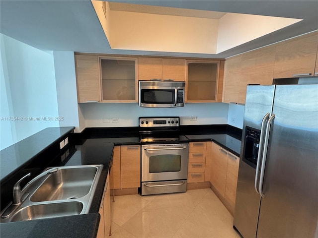 kitchen with light brown cabinetry, sink, stainless steel appliances, and light tile patterned flooring