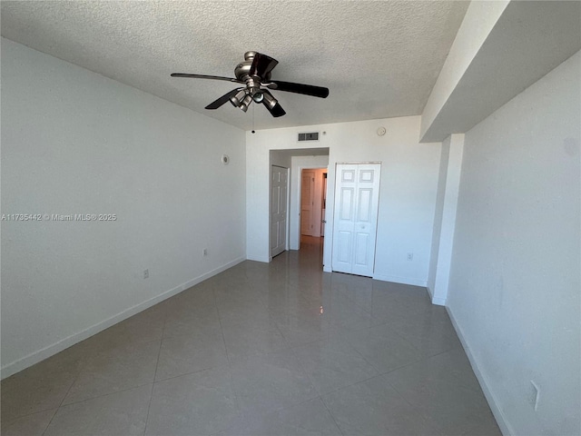 tiled empty room featuring a textured ceiling and ceiling fan