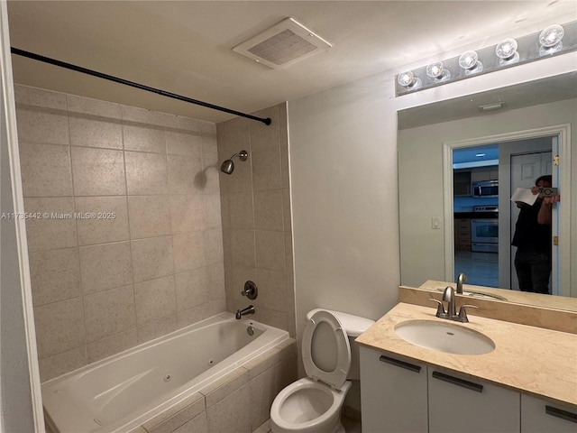 full bathroom featuring vanity, toilet, and tiled shower / bath combo