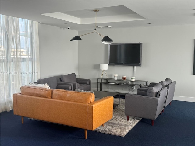 carpeted living room with a tray ceiling