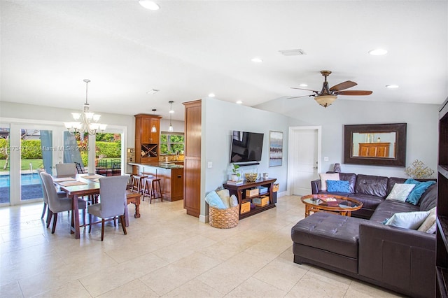 living room with ceiling fan with notable chandelier and vaulted ceiling