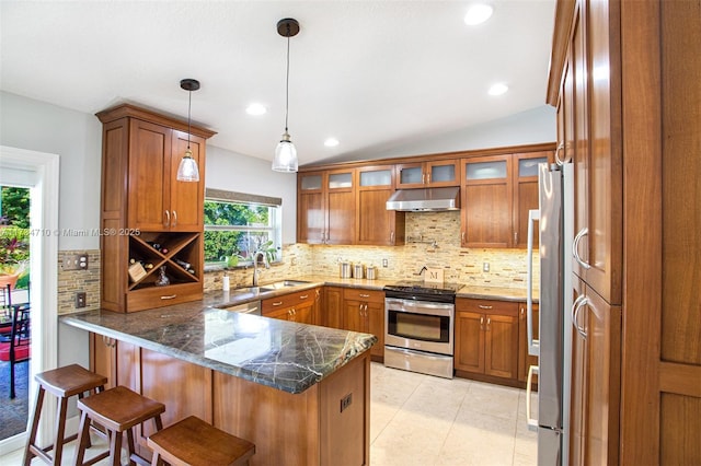 kitchen with stainless steel appliances, sink, a kitchen breakfast bar, and kitchen peninsula