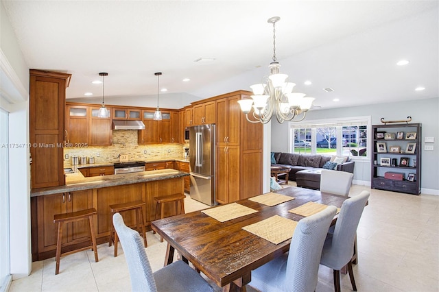 dining area featuring vaulted ceiling and a notable chandelier