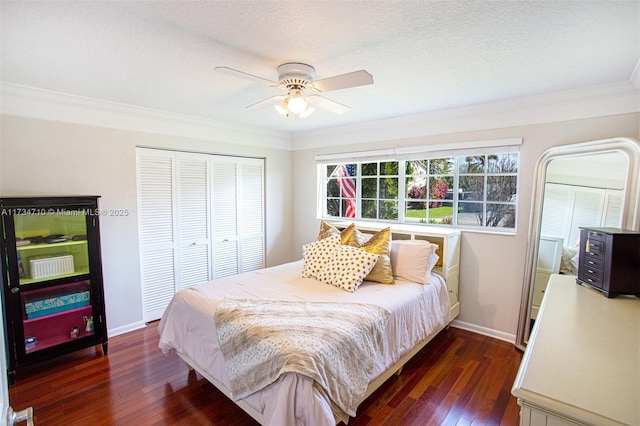 bedroom with crown molding, a textured ceiling, dark hardwood / wood-style flooring, a closet, and ceiling fan