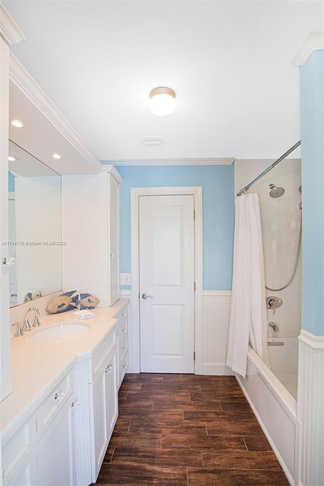 bathroom with hardwood / wood-style flooring, ornamental molding, vanity, and shower / bath combo