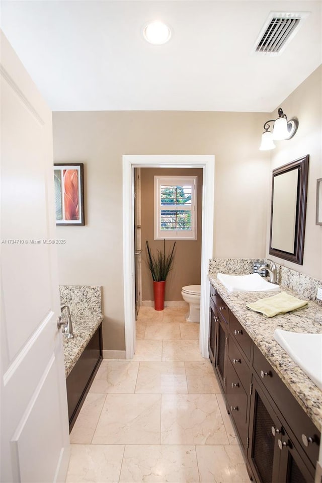 bathroom with a tub to relax in, toilet, and vanity