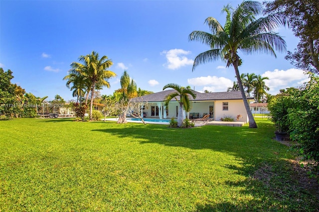 rear view of property featuring a patio area and a lawn