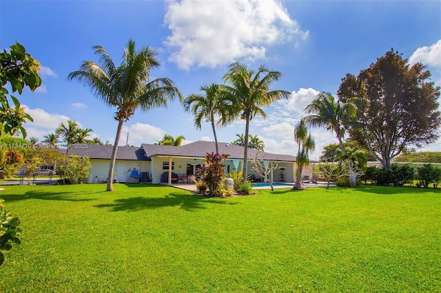 back of property with a yard and a patio area