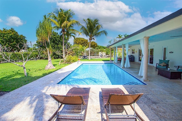 view of swimming pool with a patio and a yard