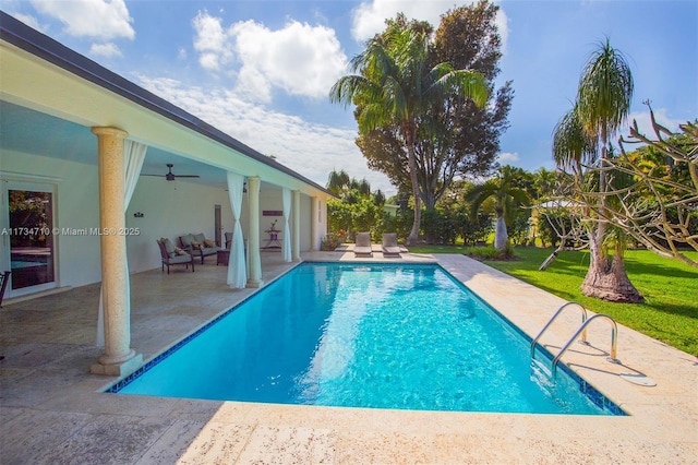 view of pool with ceiling fan, a patio area, and a lawn