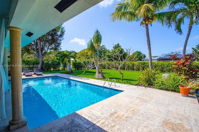 view of swimming pool with a yard and a patio area