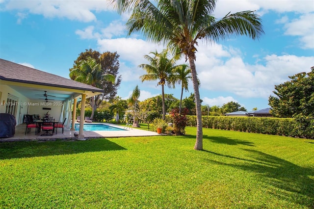 view of yard with a fenced in pool, a patio area, and ceiling fan