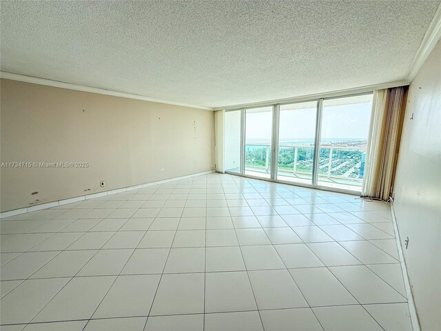 bedroom with light tile patterned flooring, a wall of windows, and a textured ceiling